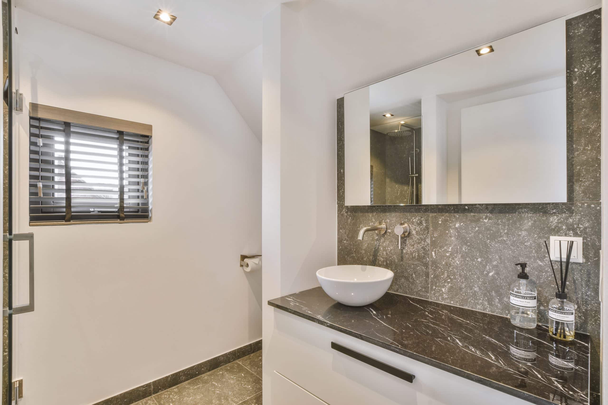 Open shower in gray tiled room