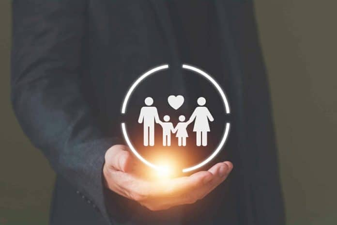 Une main tenant une icône de famille protégée avec un cercle lumineux.