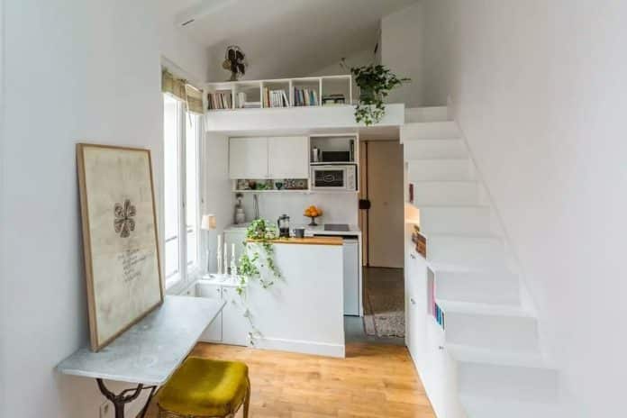 Intérieur d'un petit appartement avec un coin cuisine moderne et une mezzanine.
