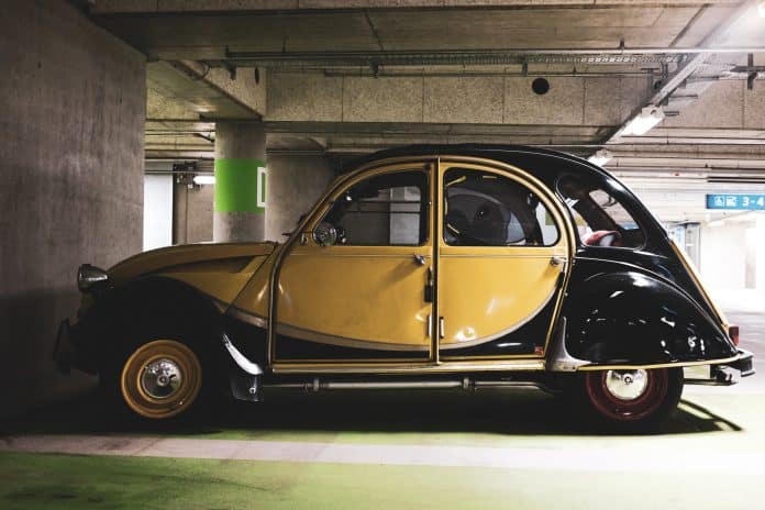 vintage-car-in-underground-parking-garage-yellow-2026-09-21-22-49-34-utc Garage de voiture ancienne